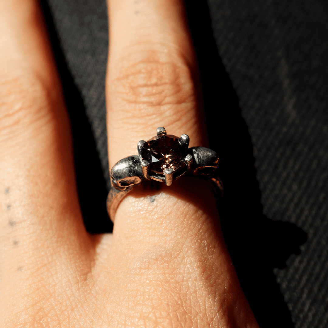 Izanami-Ring mit zwei Totenköpfen aus 925er Silber und Granatstein