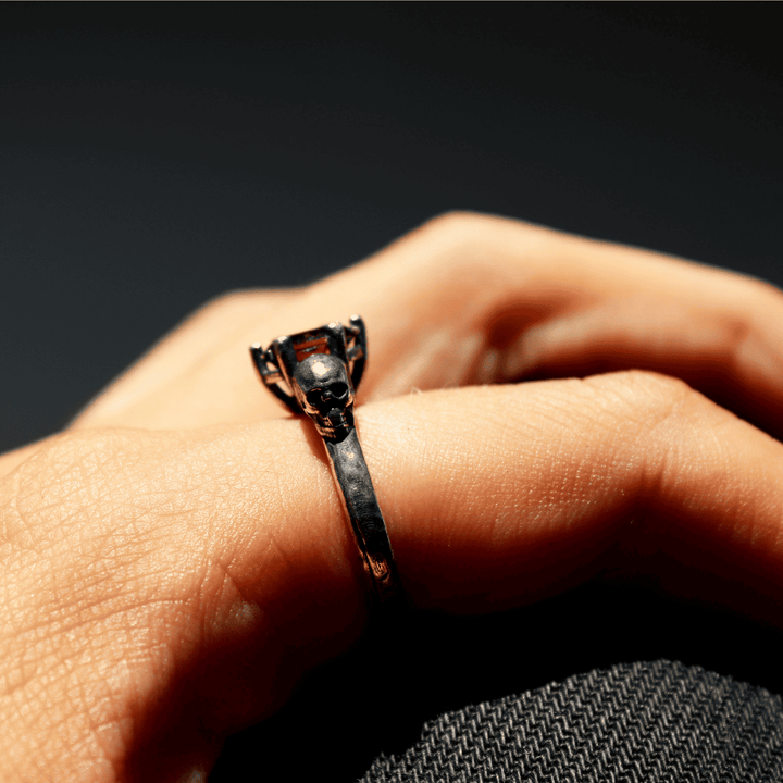 Izanami-Ring mit zwei Totenköpfen aus 925er Silber und Granatstein