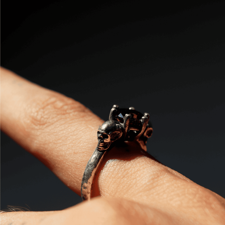 Izanami-Ring mit zwei Totenköpfen aus 925er Silber und Granatstein