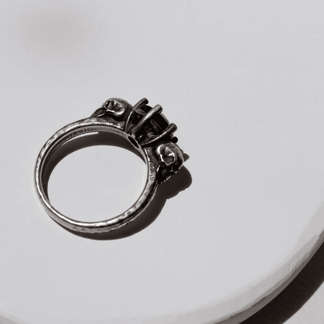 Izanami-Ring mit zwei Totenköpfen aus 925er Silber und Granatstein