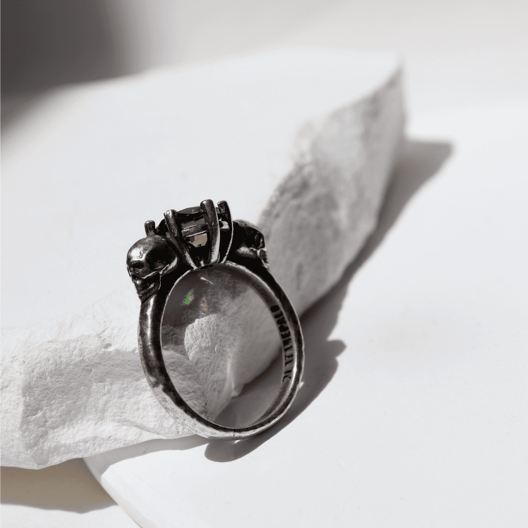 Izanami-Ring mit zwei Totenköpfen aus 925er Silber und Granatstein