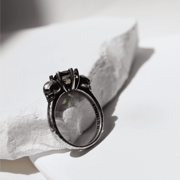 Izanami-Ring mit zwei Totenköpfen aus 925er Silber und Granatstein